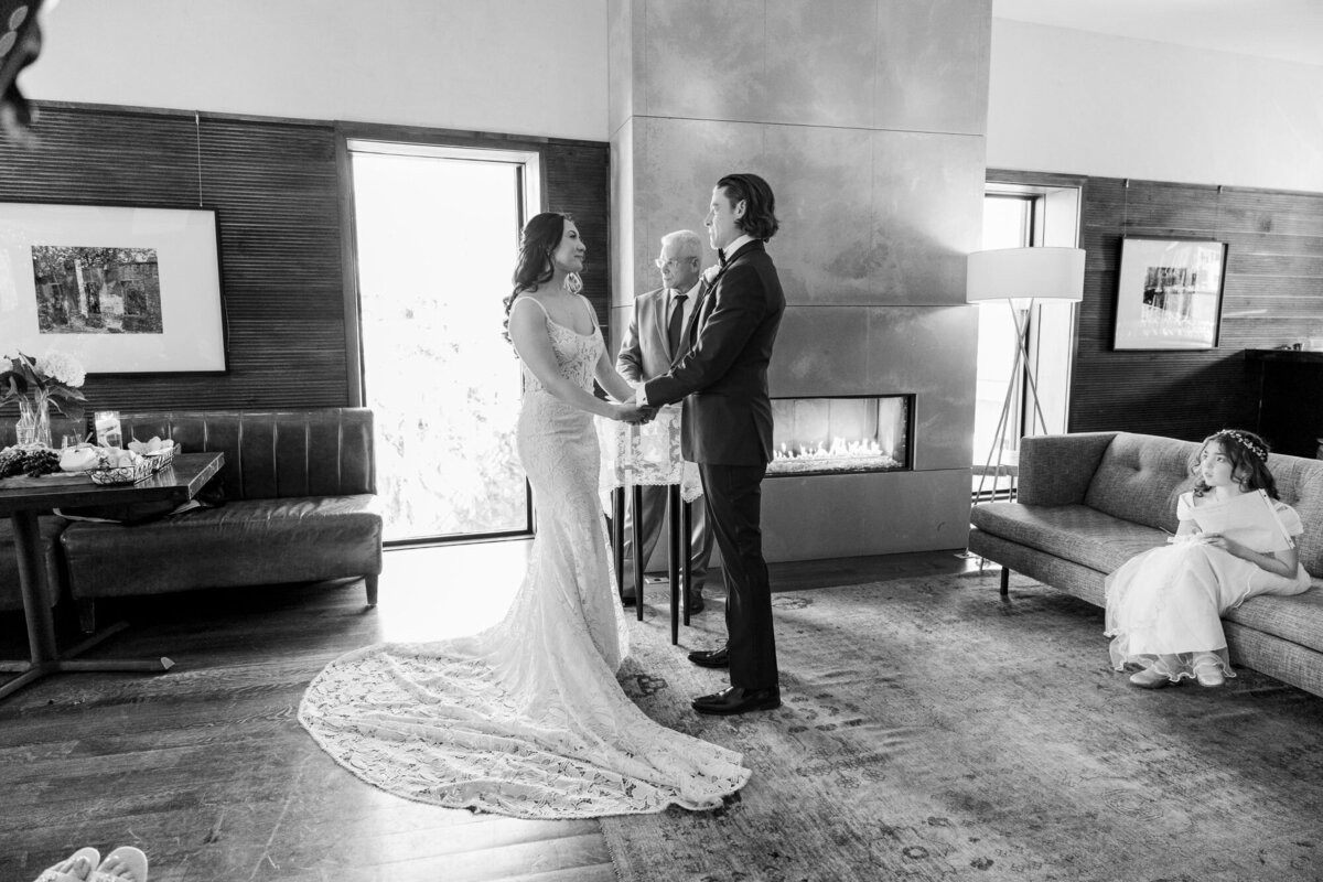 Bride and groom have an intimate wedding ceremony at The Roundhouse in front of the fireplace in the lounge