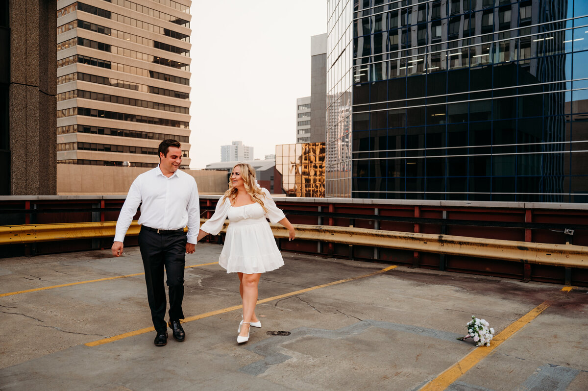 Engaged couple walks hand in hand at the Rice Howard Parkade in Edmonton