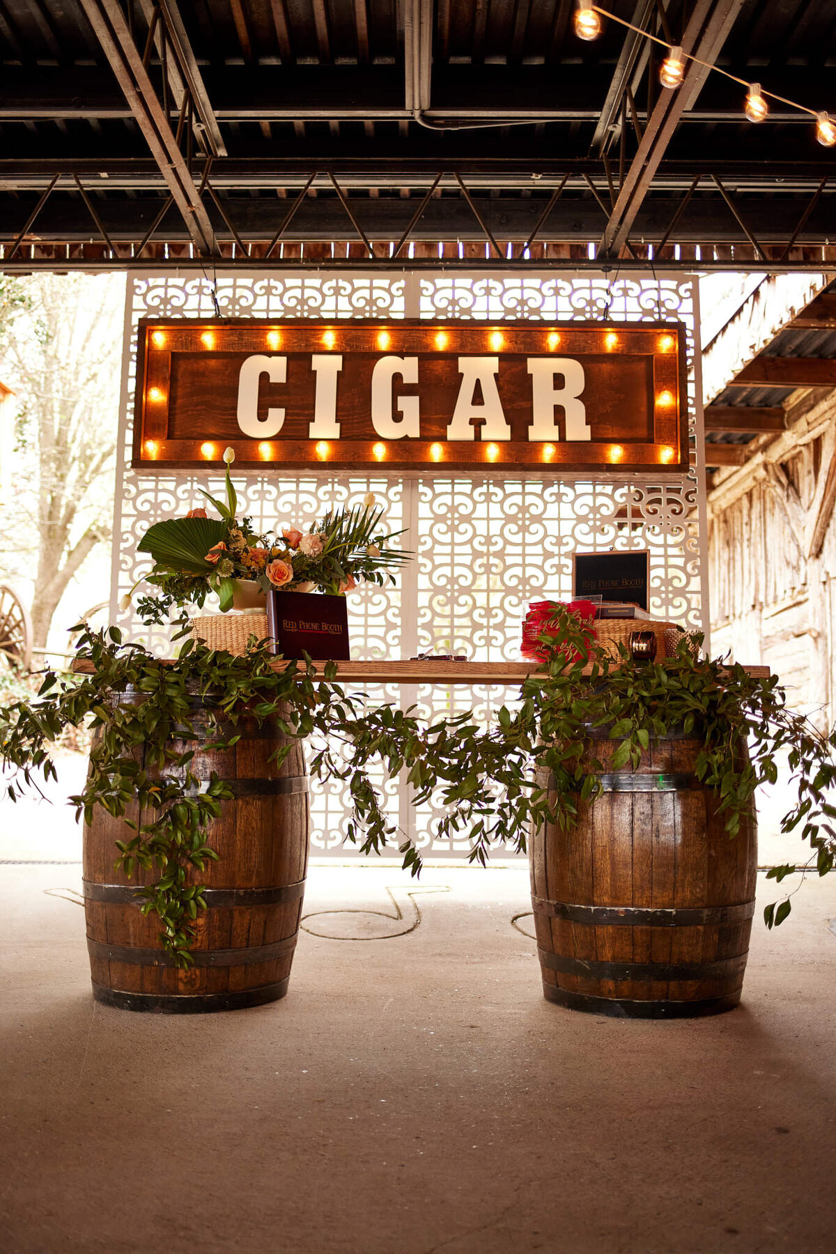 barrel cigar bar with greenery and tropical arrangement at Legacy Farms