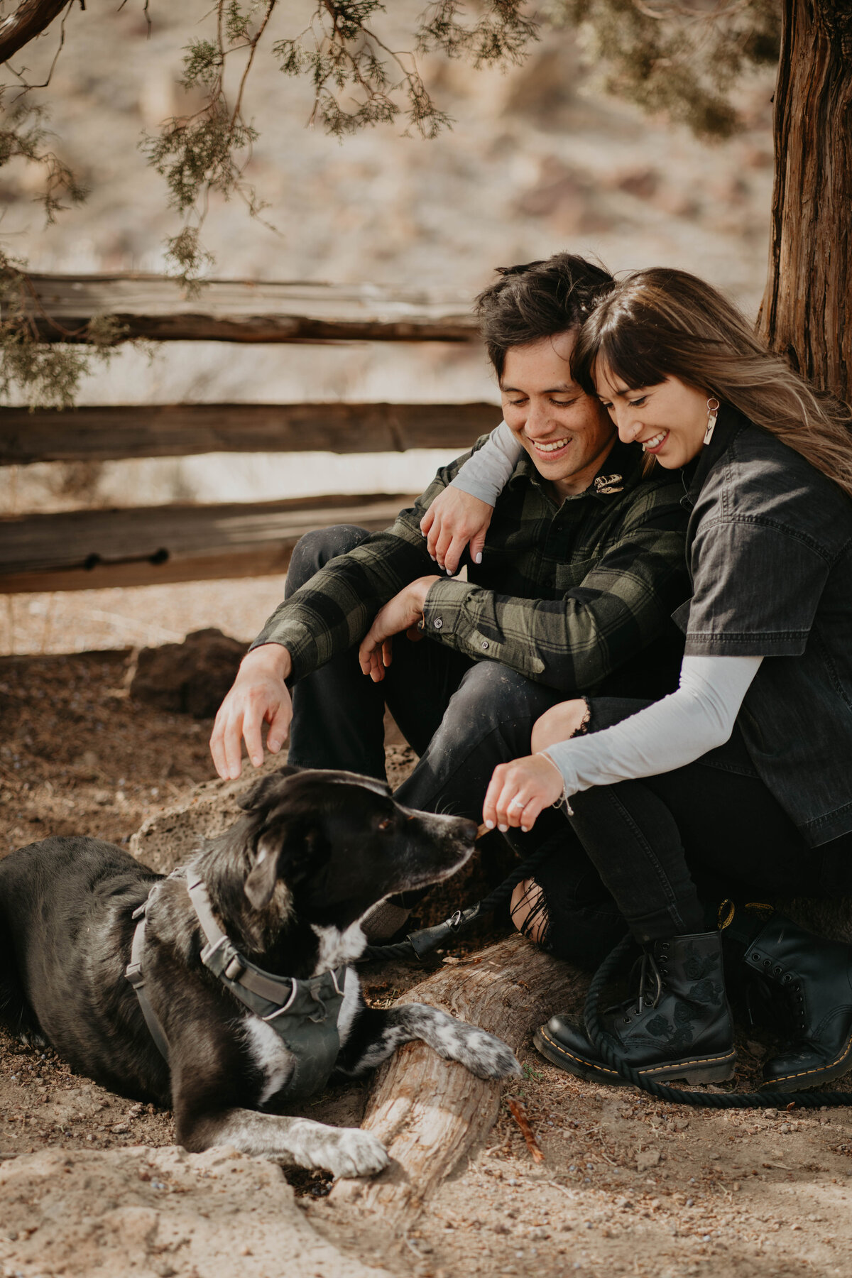 Couple cuddling with their dog during Smith Rock engagement photos