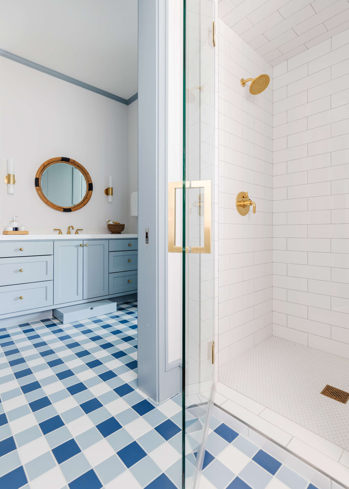 oyster creek studios memorial new build blue tiled bathroom with white tiled shower with gold hardware and light blue vanity bathroom