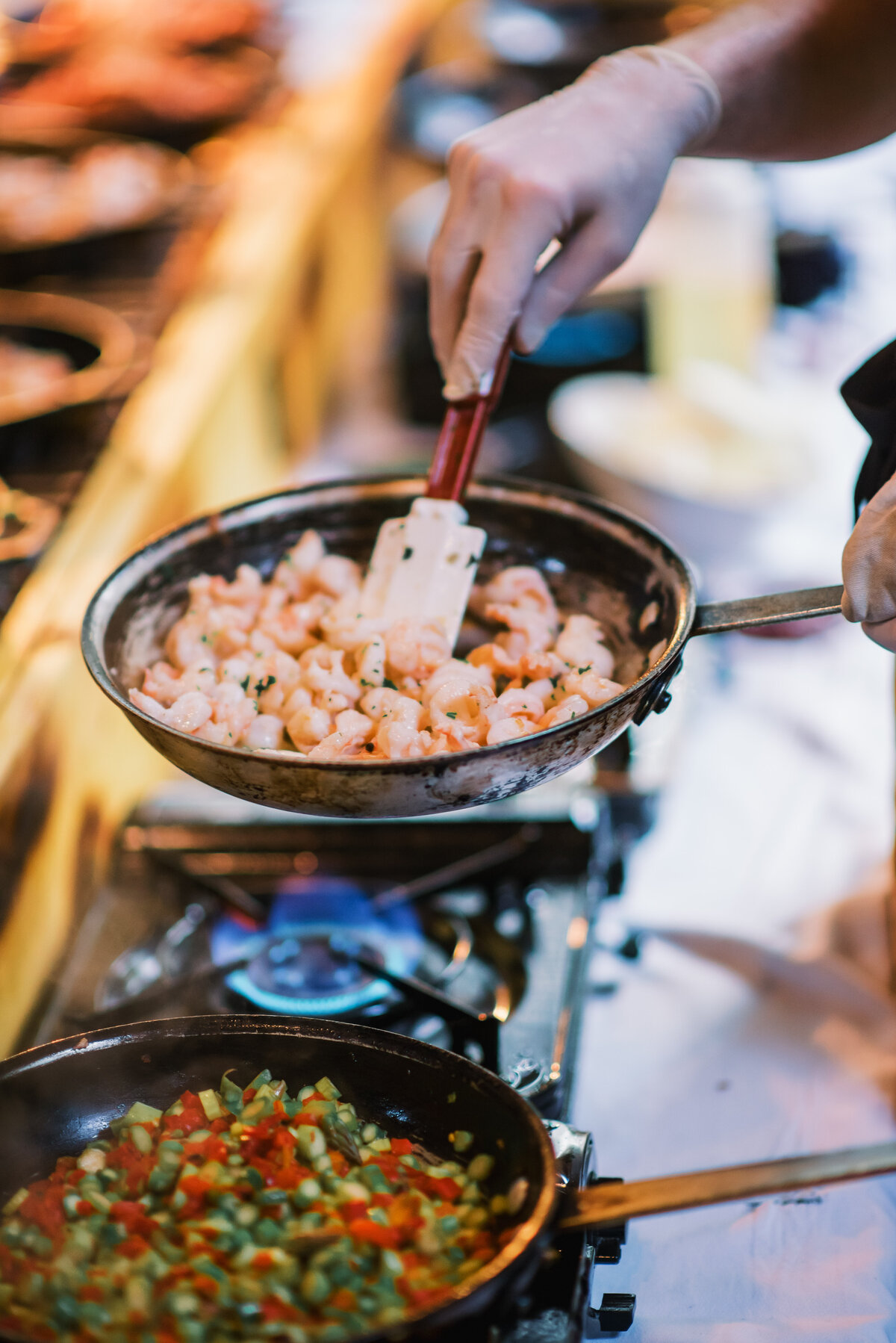 Chef cooking shrimp at a live action catering station during a wedding reception at Old Edwards Inn in Highlands, North Carolina.
