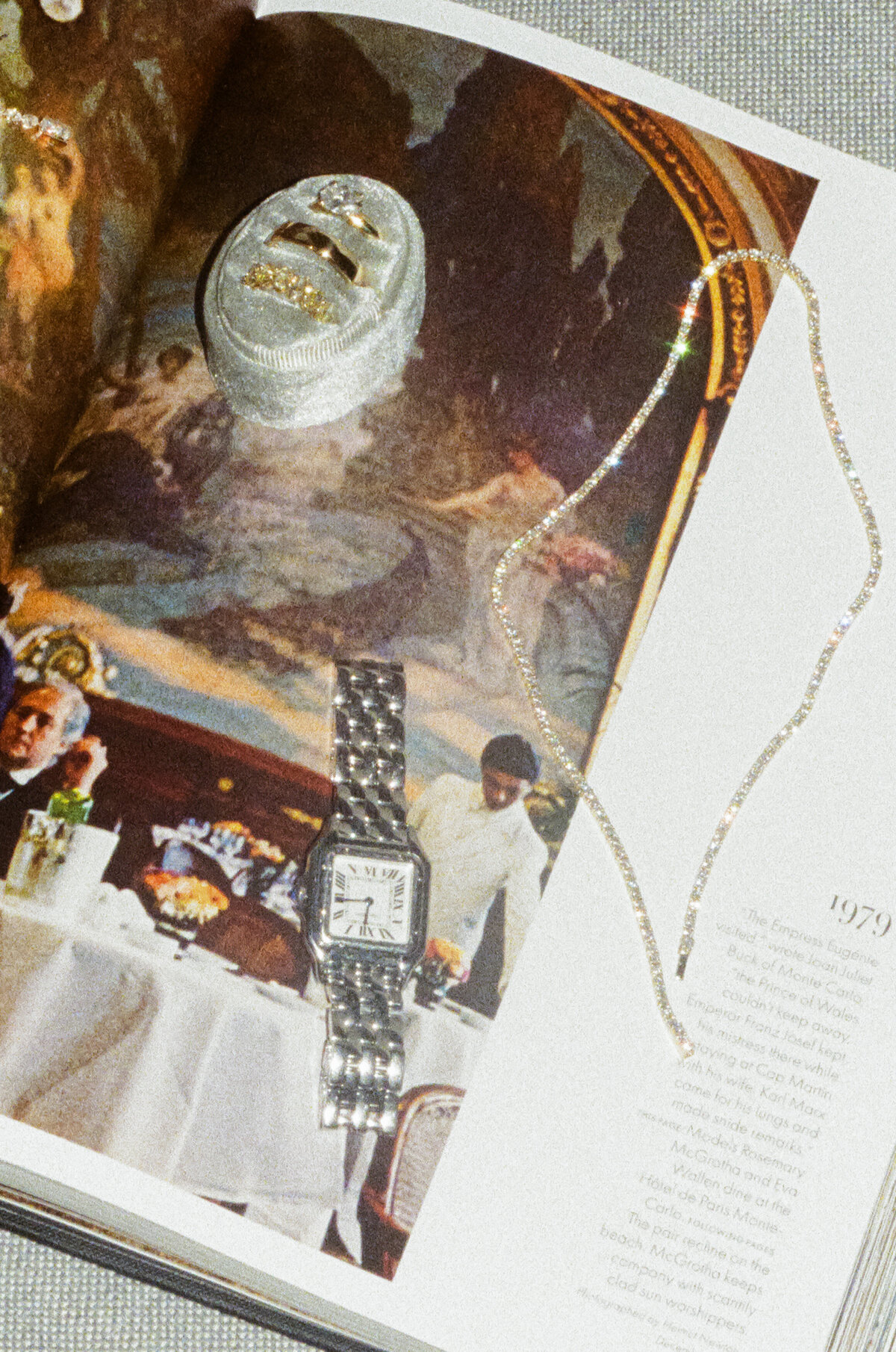 Exquisite groom's accessories and personal details artfully arranged with vintage magazines, showcasing editorial wedding photography approach with warm film tones capturing authentic luxury wedding moments at NOBU Hotel Chicago.