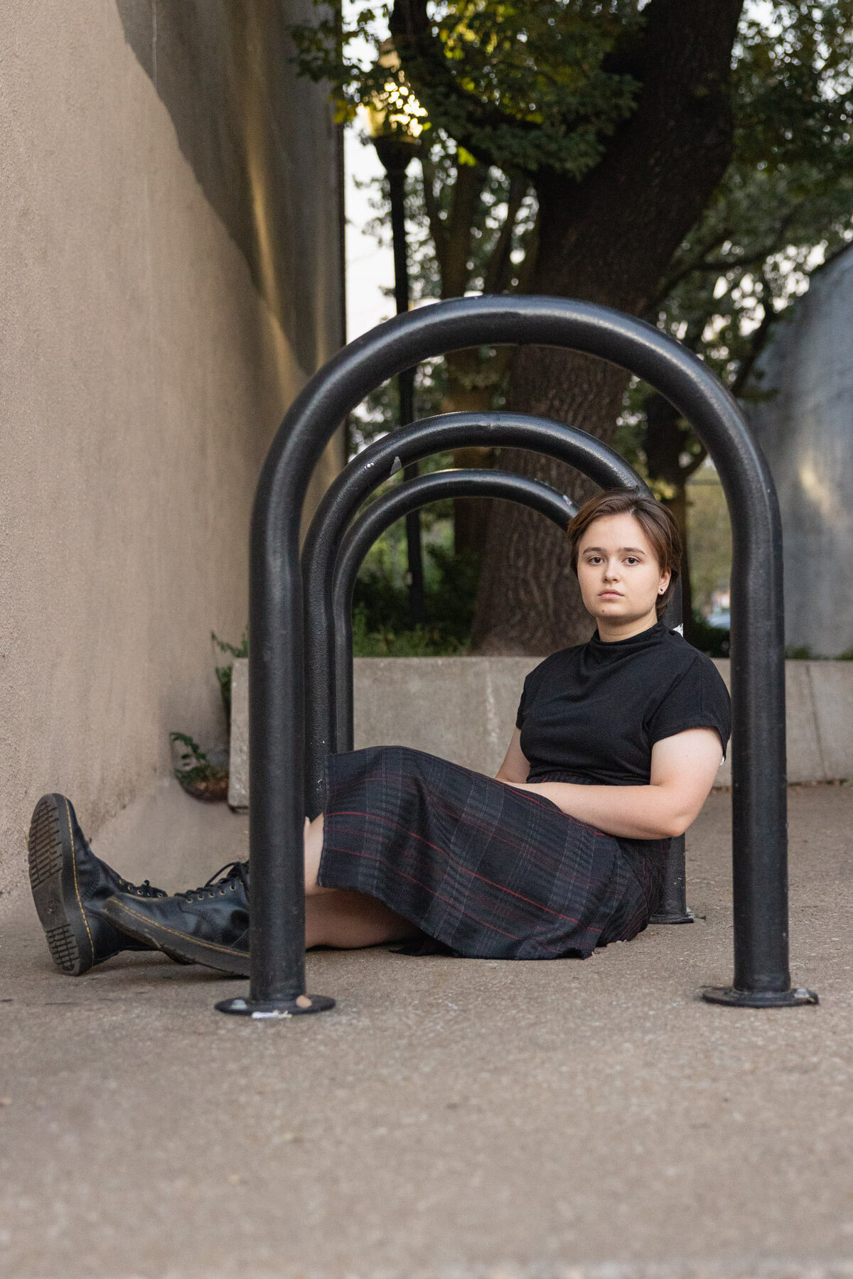 A senior girl sitting in between the bike racks in downtown Lawrence KS