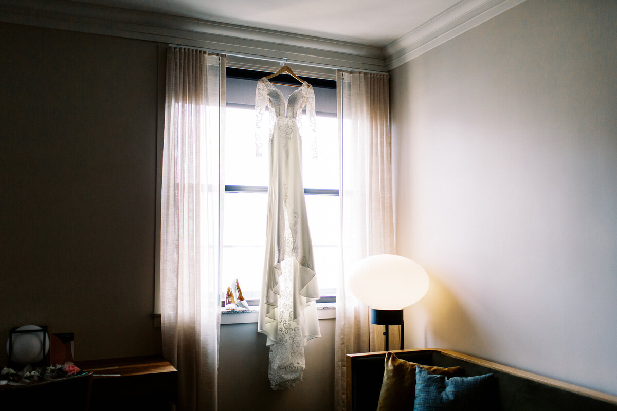 wedding dress hanging over the large window in minneapolis