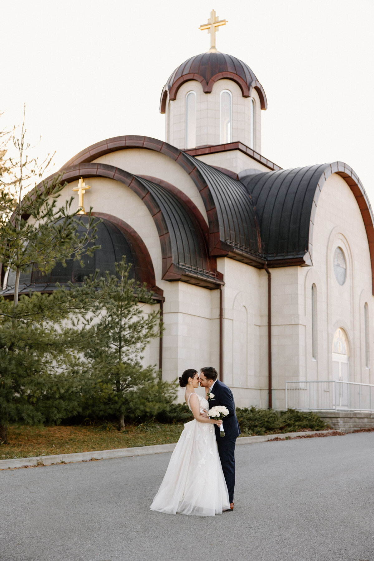A couple kiss in front of St. Stefan Serbian Orthodox Church after their wedding ceremony