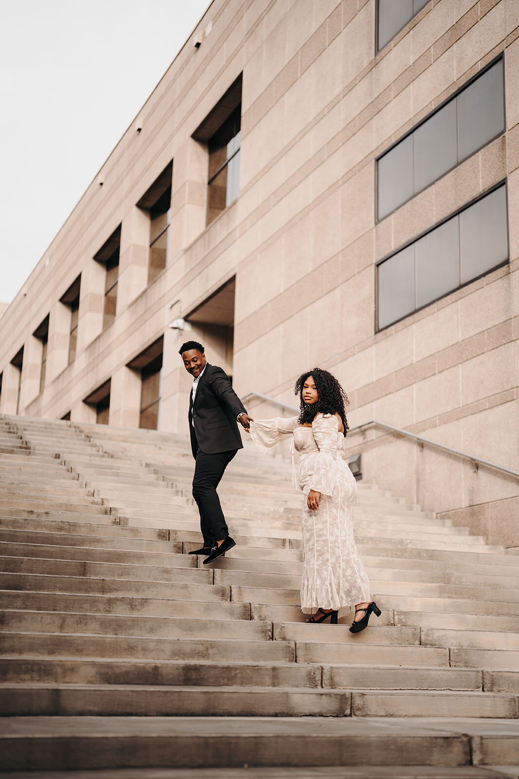 An engaged couple walking up the stairs in Charlotte, NC.