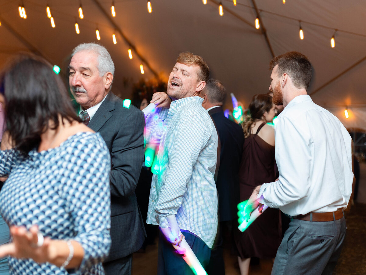 A wedding guest sings as he dances during a wedding reception.