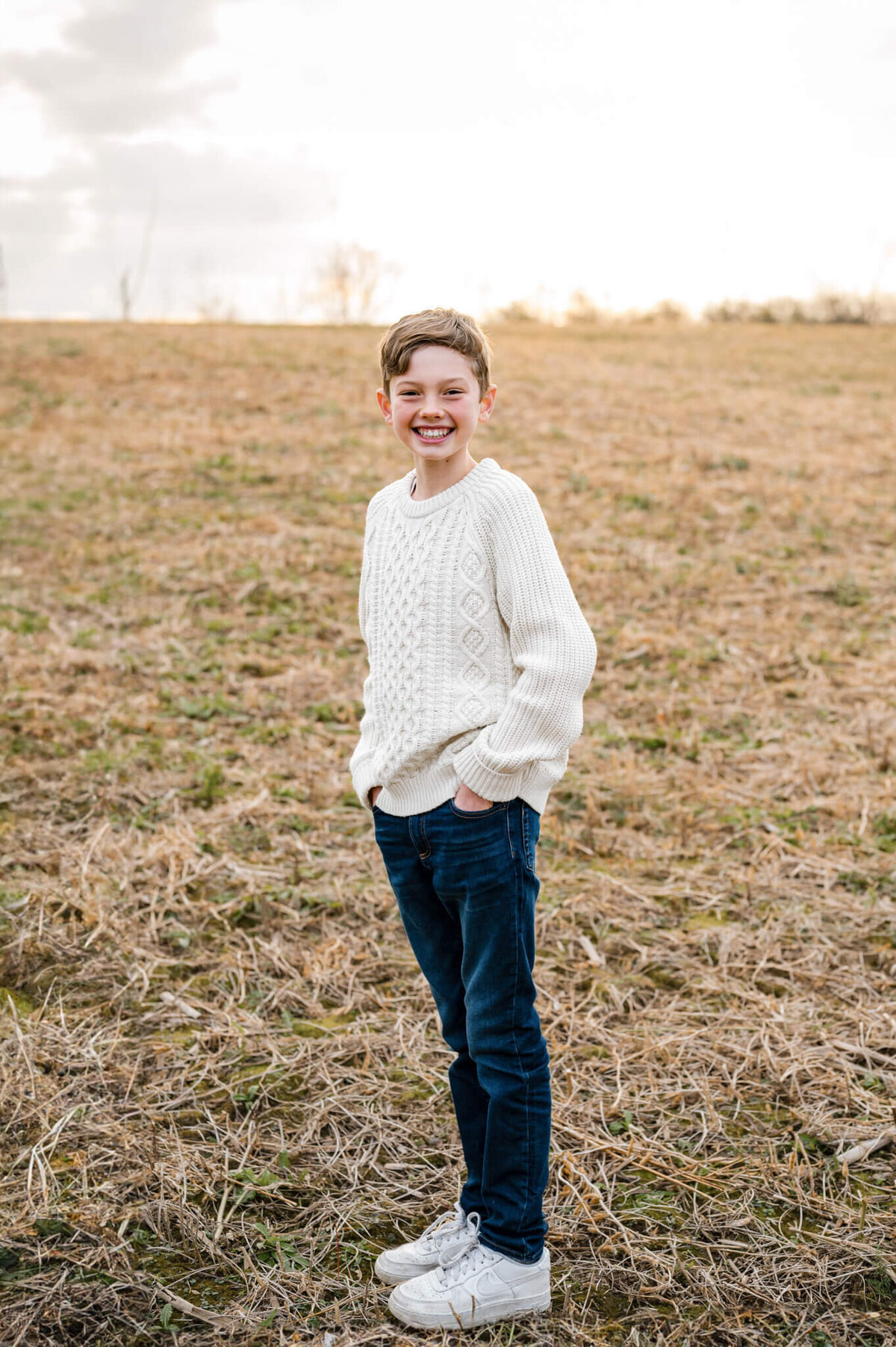 young boy posing with hands in pockets