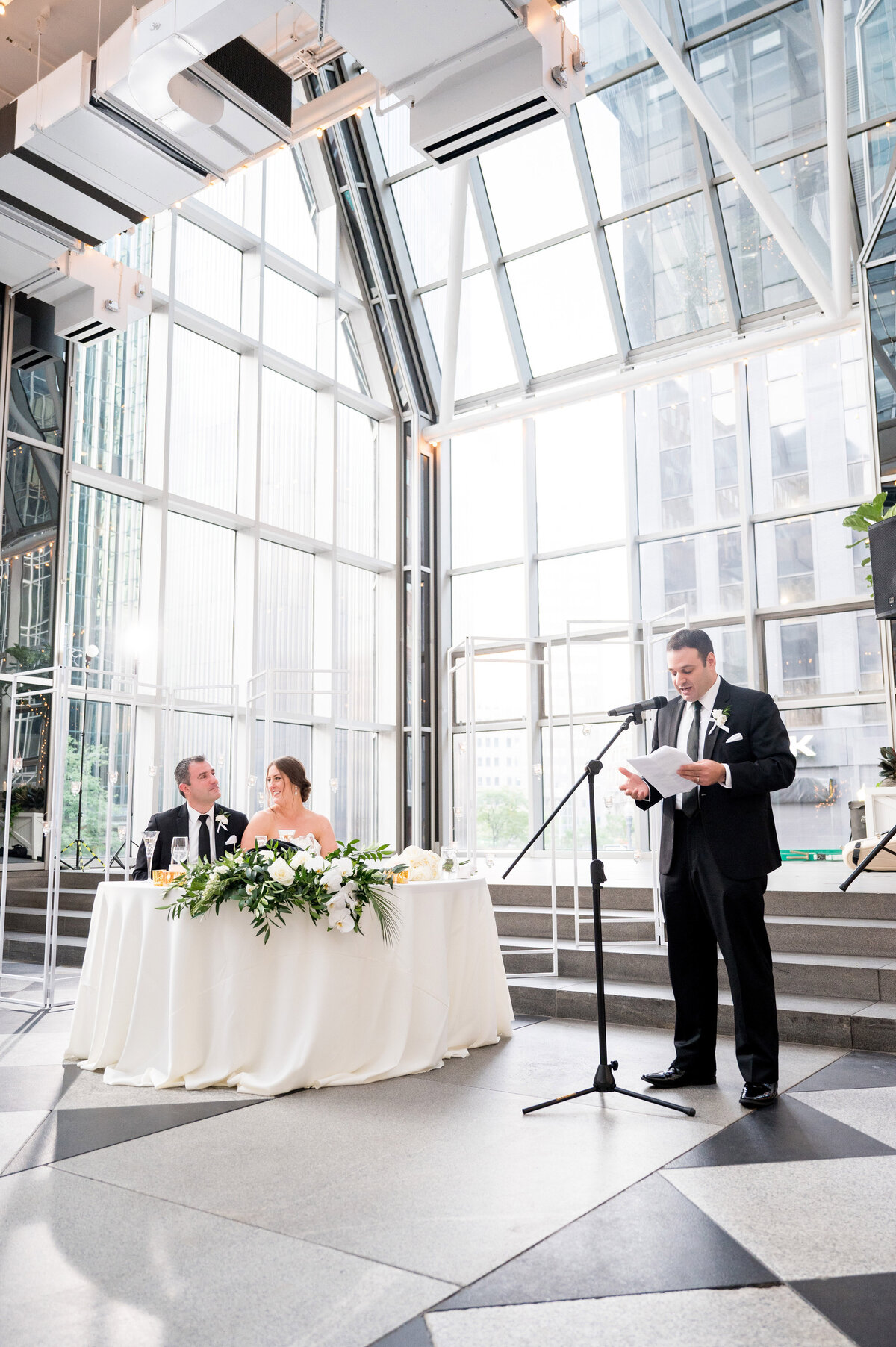 best man giving a wedding toast with scenery ar wedding venue lots of glass walls wintergarden ppg