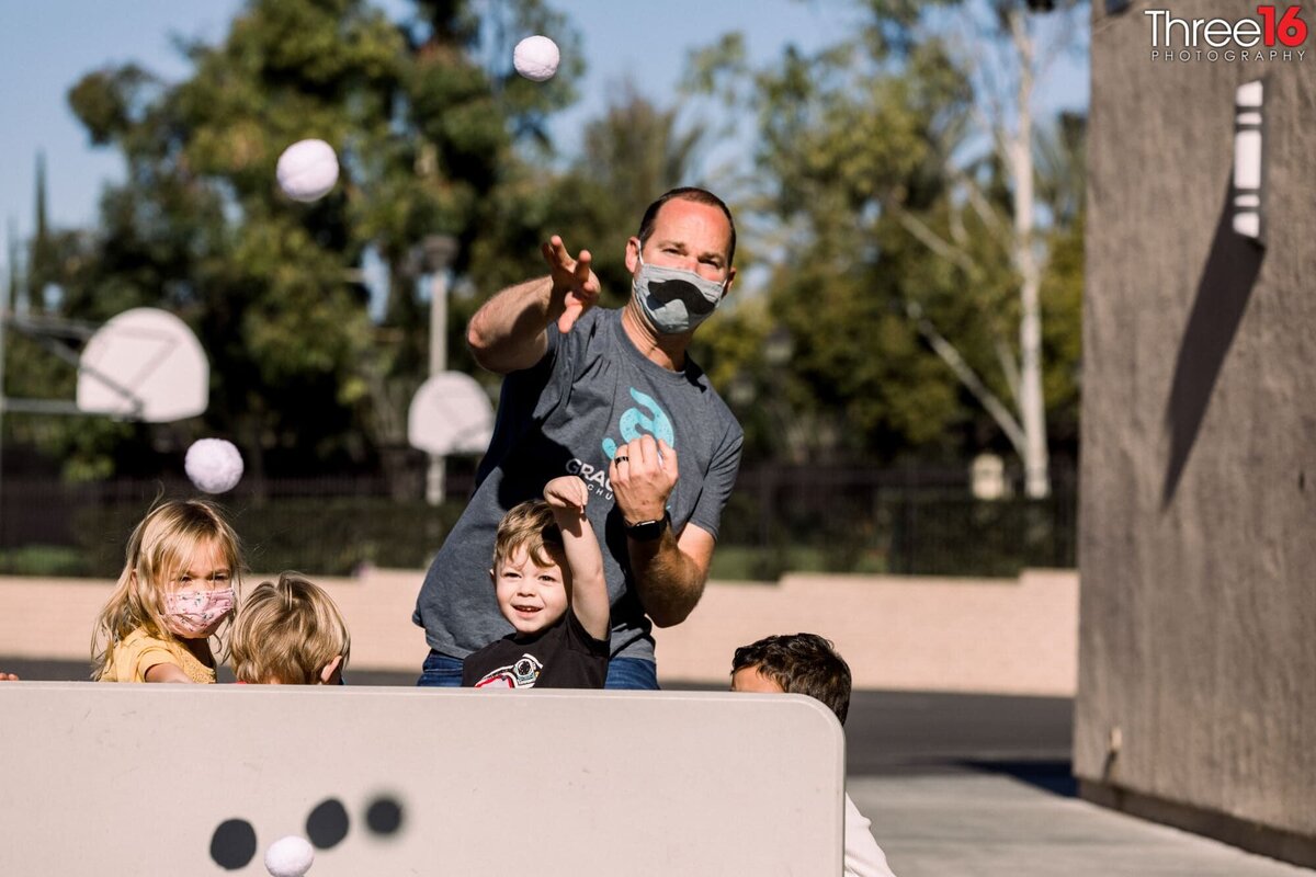 Dad and his son toss balls during a fun event during a church picnic