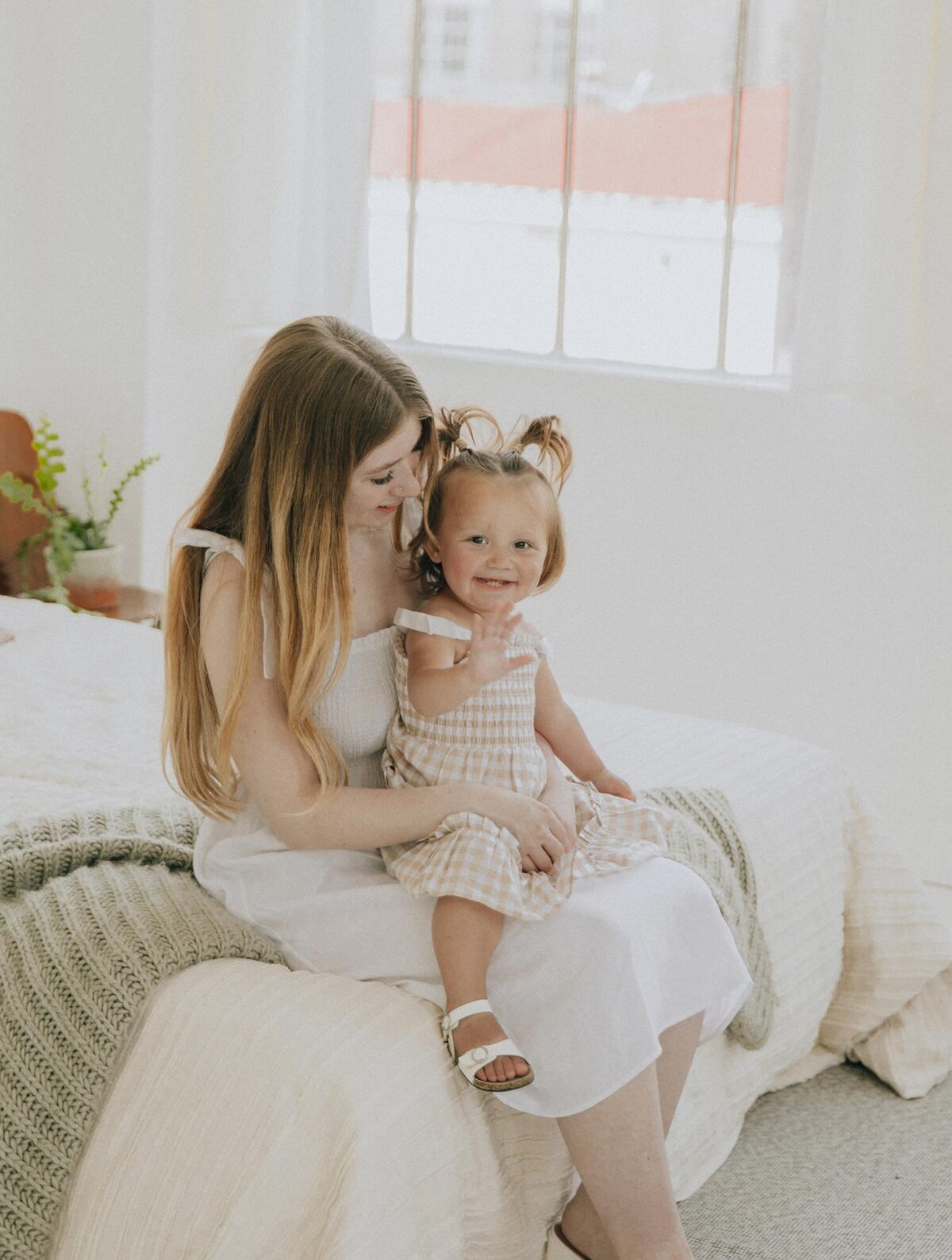 girl sitting on mom's lap and smiling at the camera