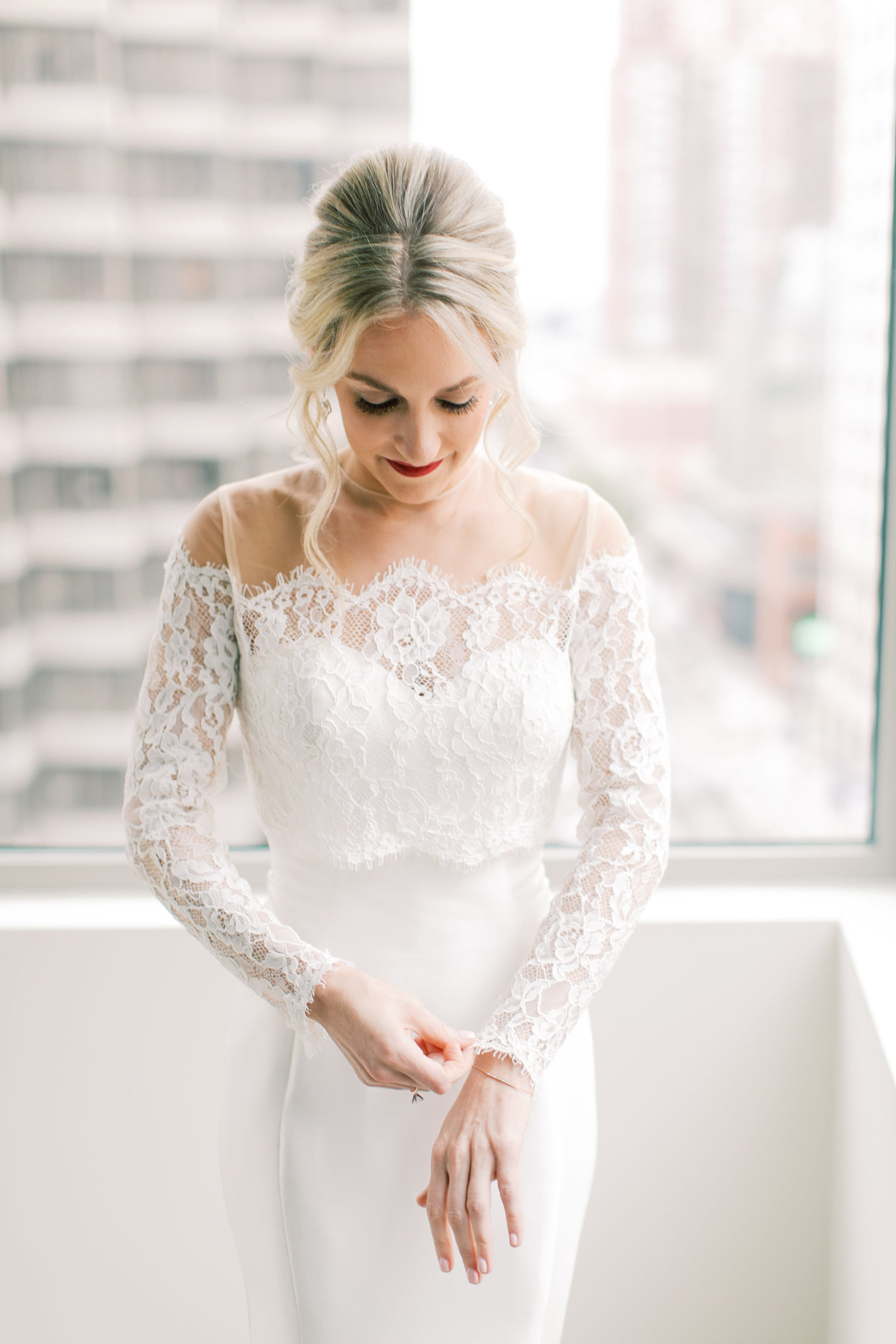 bride adjusting sleeves on lace wedding gown
