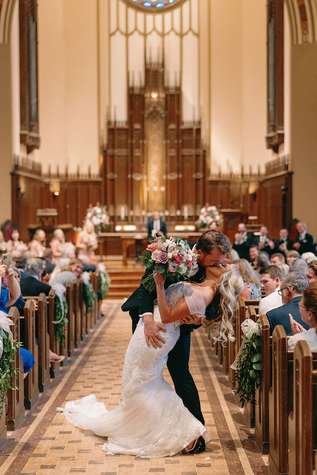 Bride and groom kiss after walking down the aisle at Memorial Presbyterian Church in St. Louis