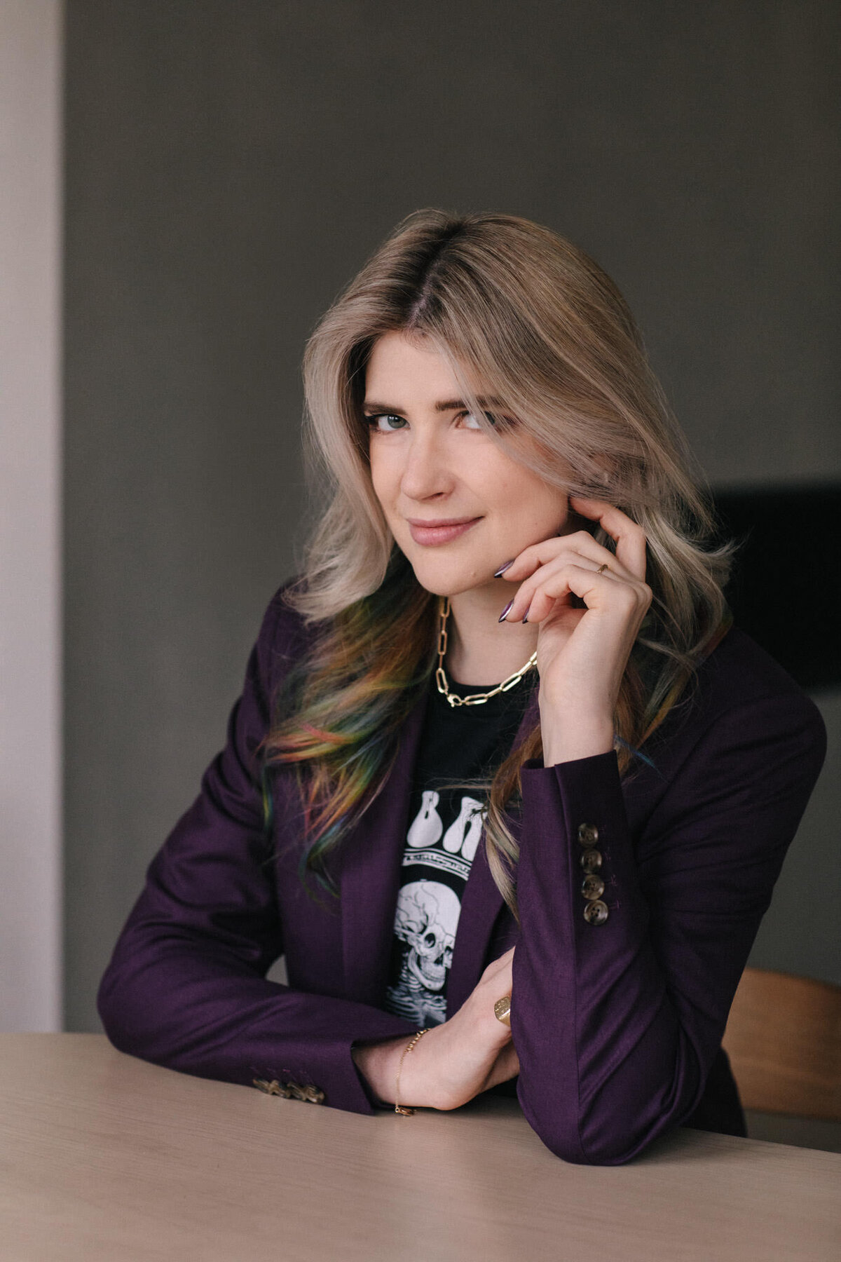 author portrait of taylor grothe with rainbow hair and a purple suit