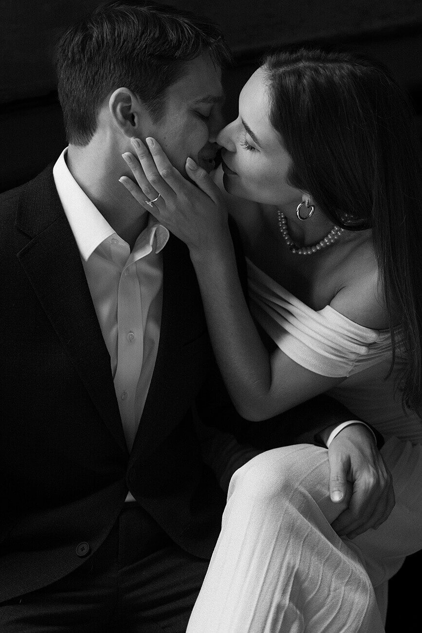 black and white photo of couple kissing with girl's hand on his face