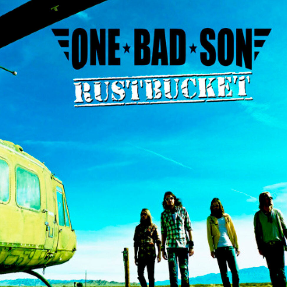 Single Cover Title Rustbucket Band One Bad Son standing in desert next to old helicopter