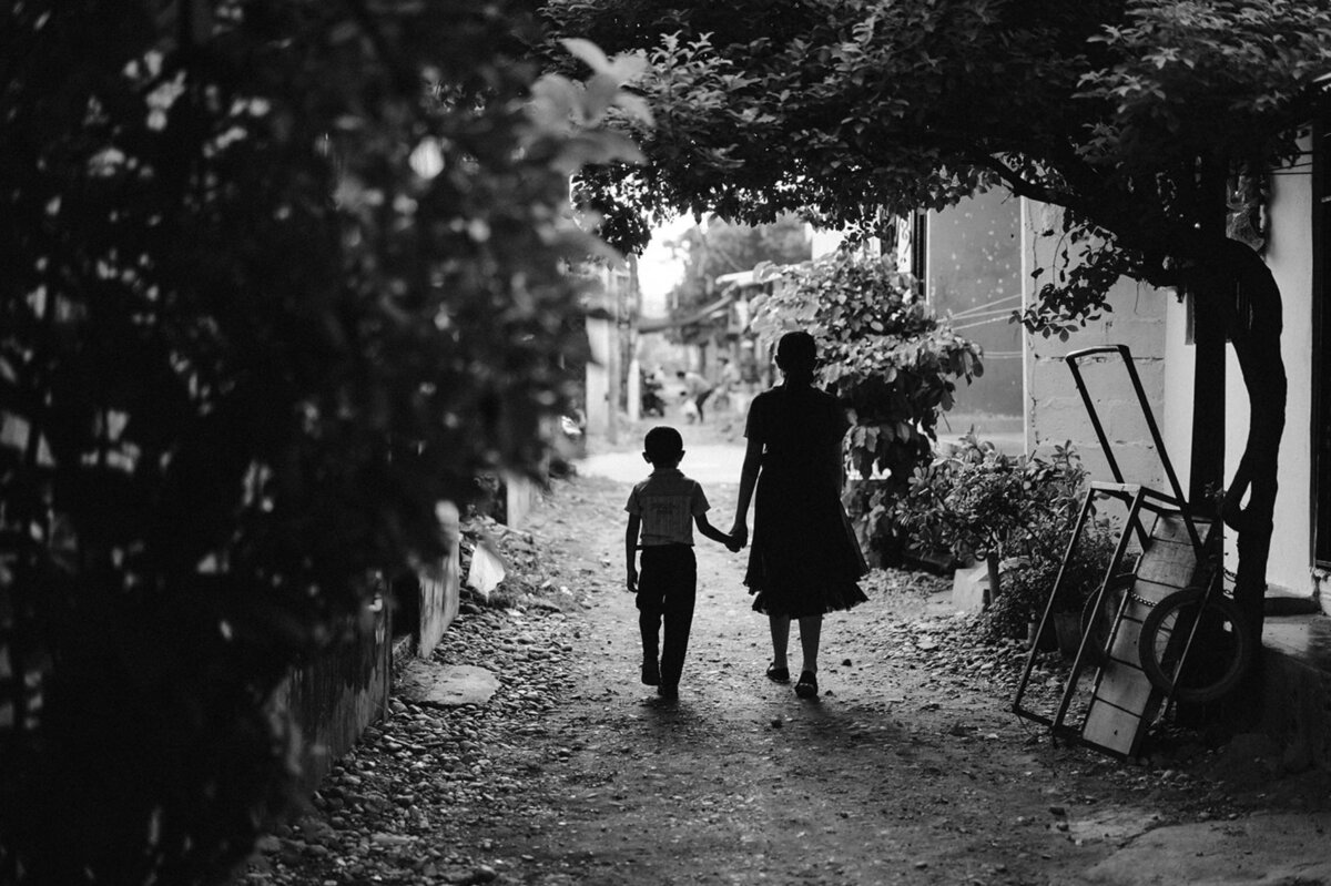 Vrouw en jongetje lopen door een lege straat