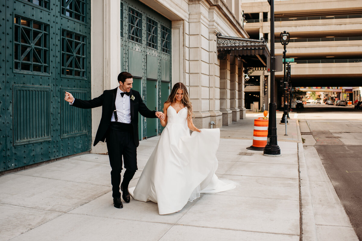 Bride and groom dancing on the sidewalk in Downtown Milwaukee