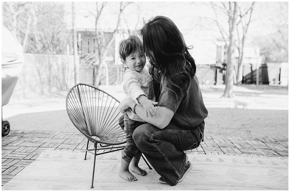 Mother crouching down hugging child at  garden family session in Austin by Amber Vickery Photography