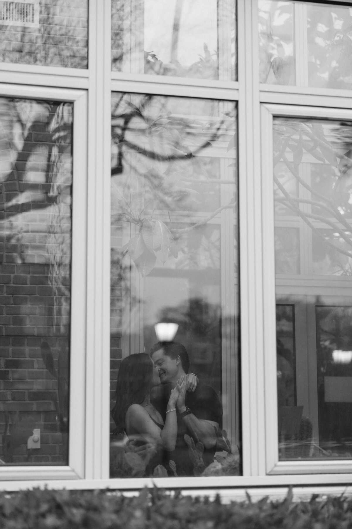 candid photo of a couple dancing in a window
