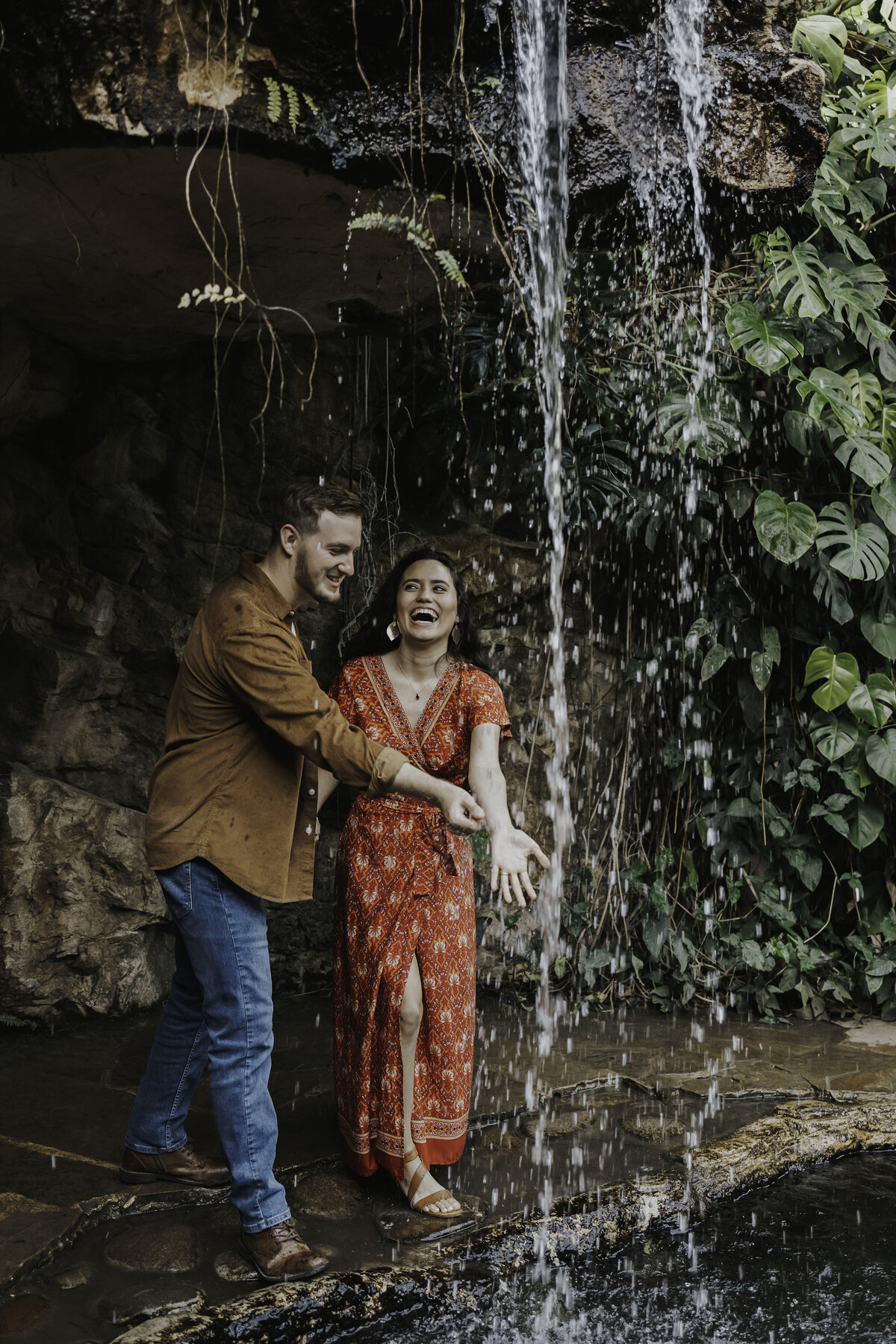 Couples playing in waterfall in hawaii