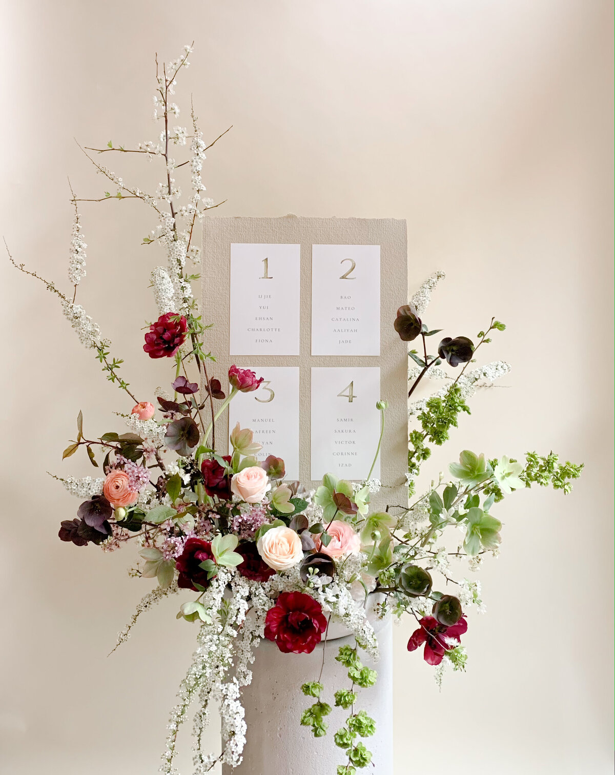 An airy floral arrangement with roses and greenery decorating a place card display for a Montreal wedding.
