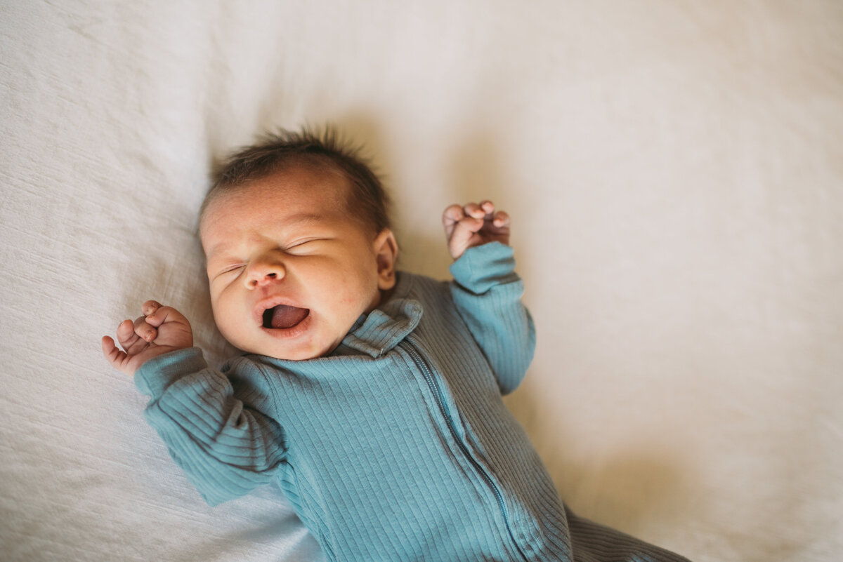 newborn baby laying on bed