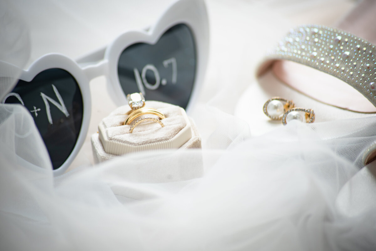 Explore the essentials of a beautiful day, including rings, glasses, and shoes, all elegantly captured at Anais Events Center in Bellaire, Texas
