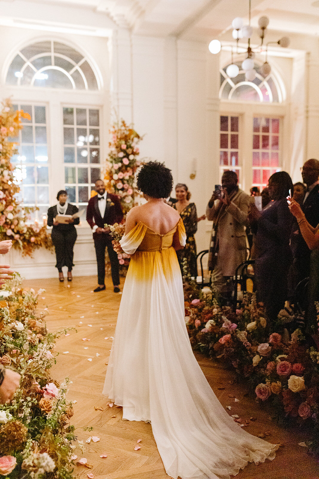 Lush aisle hedges line the entryway for this autumnal wedding with florals composed of roses, clematis, mums, delphinium, copper beech, and fall foliage creating hues of burgundy, dusty rose, copper, mauve, taupe, and lavender. Design by Rosemary and Finch in Nashville, TN.