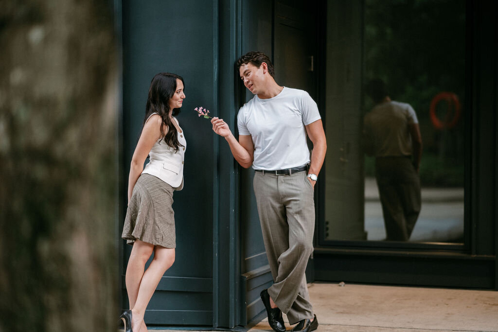 man holds flower out to girlfriend in market square in knoxville tennessee