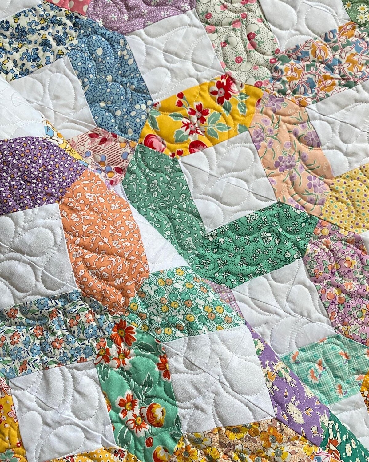 All-over feather quilting design on a floral quilt