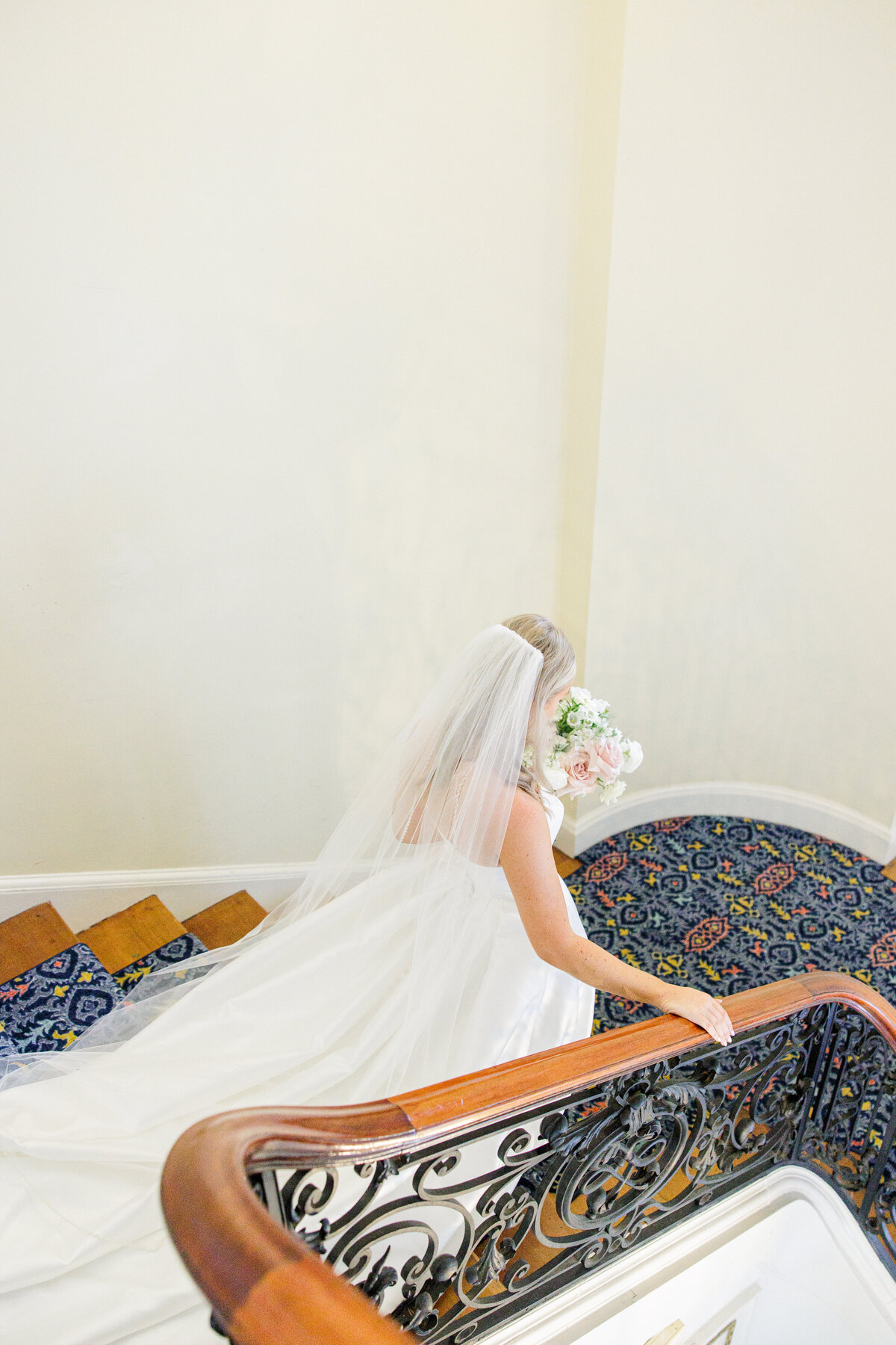 Bride walking down stairs during her Tupper Manor wedding first look