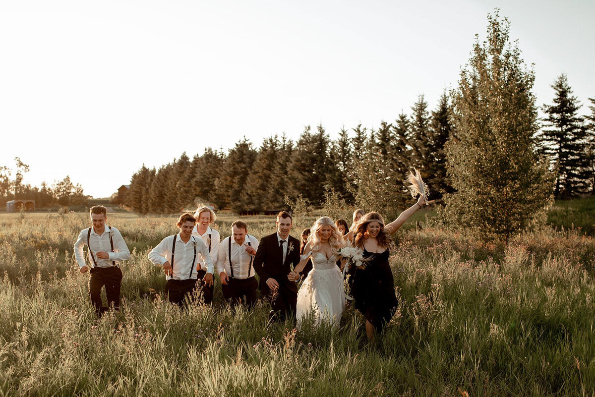 Wedding party in field at Pine & Pond, a natural picturesque wedding venue in Ponoka, AB, featured on the Brontë Bride Vendor Guide.