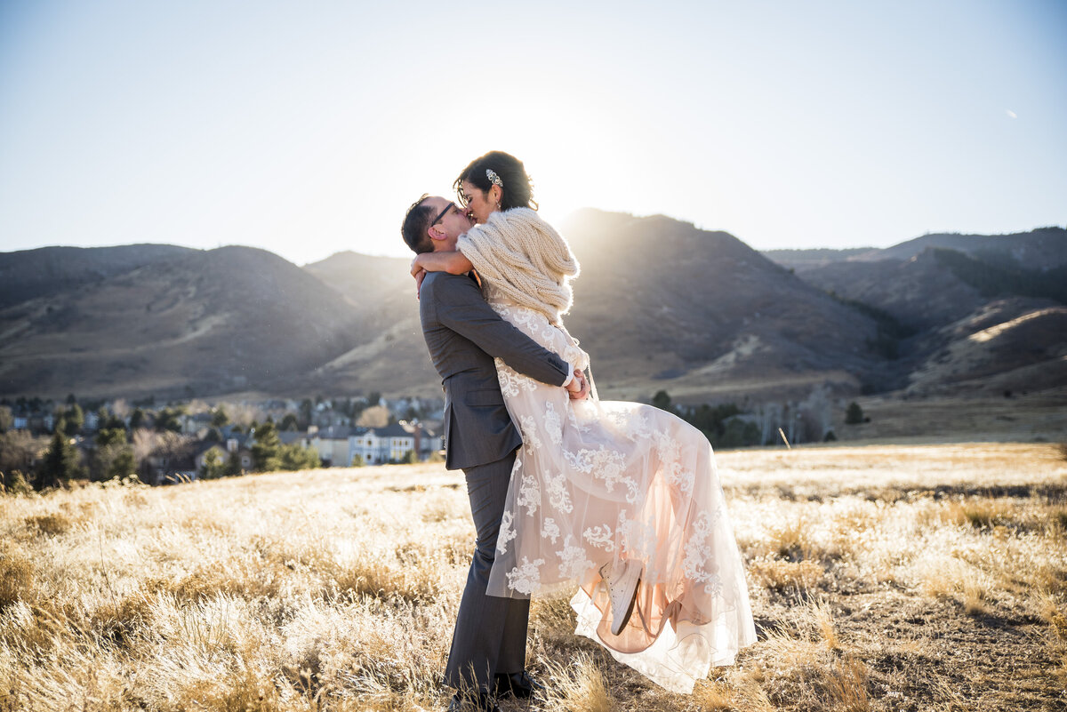 A groom lifts his bride for a twirl and spin at golden hour at The Manor House in Littleton, Colorado.
