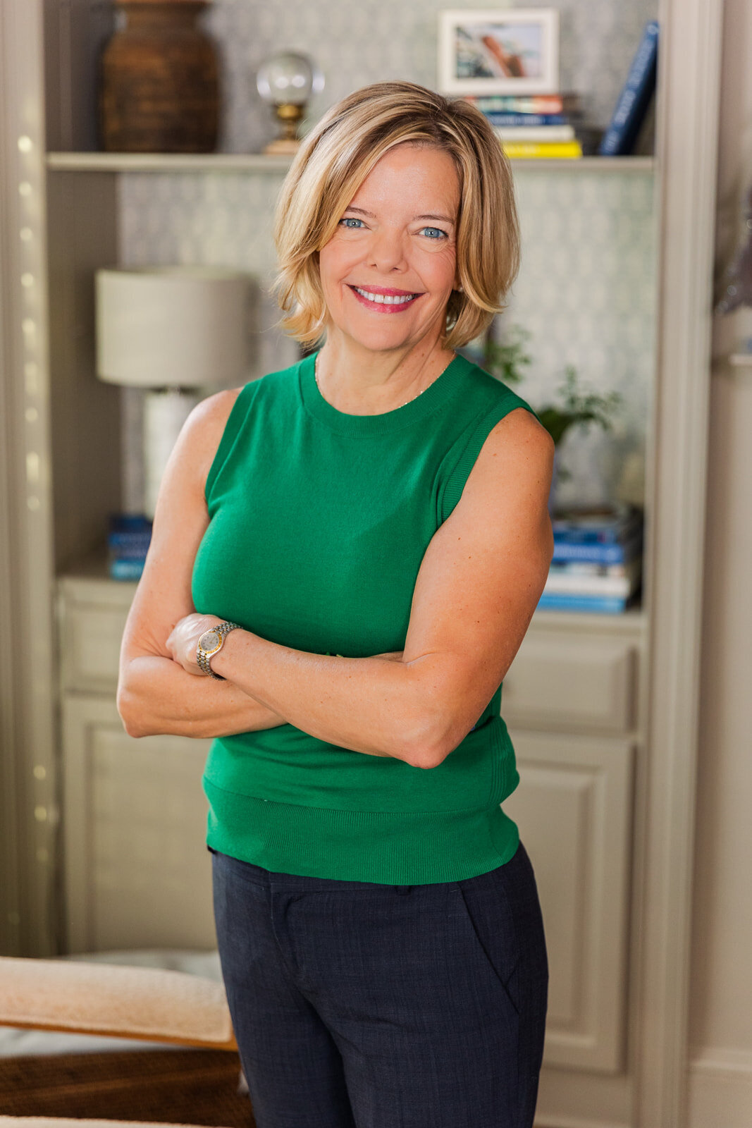 woman wearing navy pants and a green sleeveless top during at home portraits session