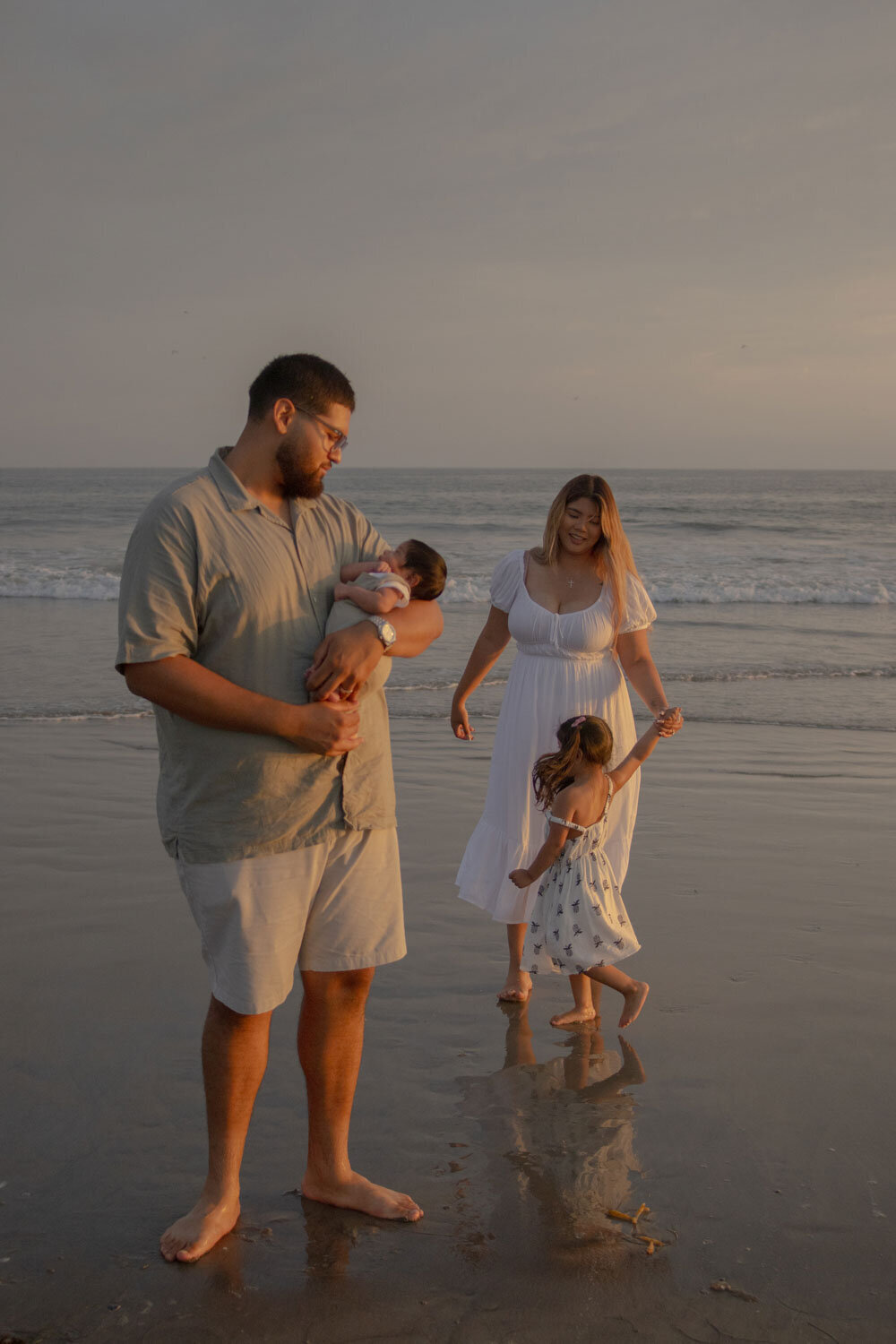Family playing in the water at dusk, captured by Molly, a San Diego family photographer