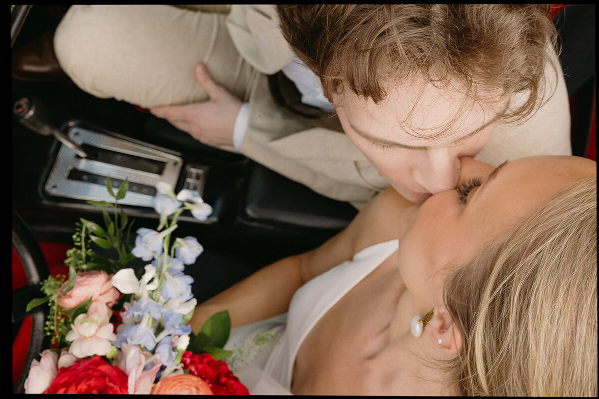 Couple share kiss in a vintage car after wedding ceremony in Nashville, TN. 