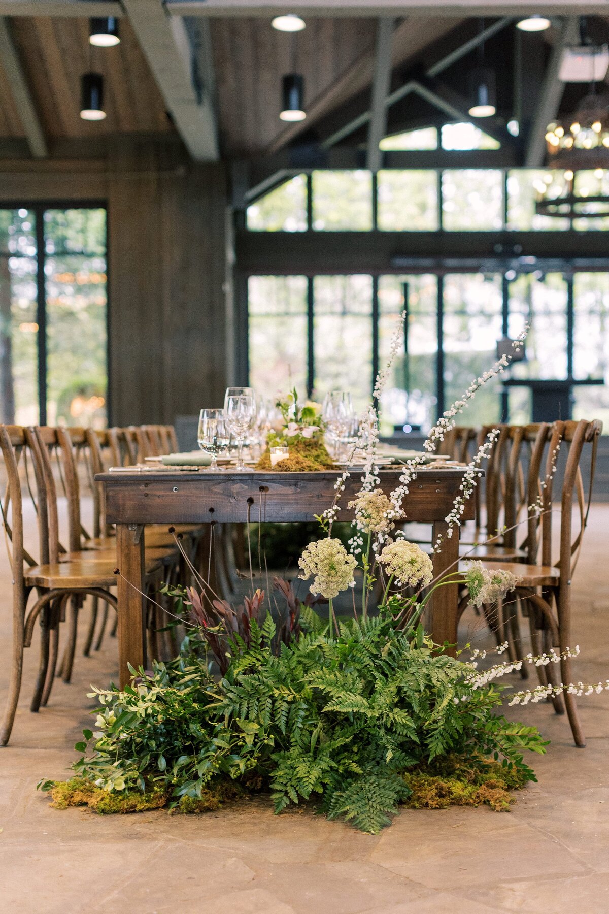 Wedding reception table with lush greenery installation