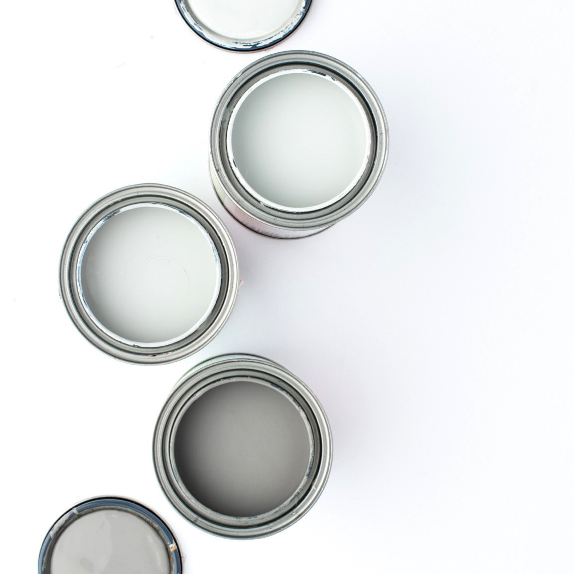 open cans of grey paints options on white background