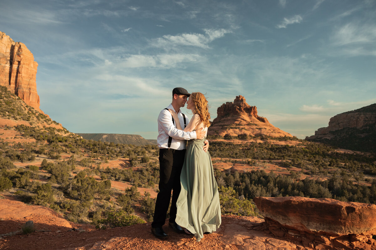 Couple standing against red rock backdrop during Sedona engagement session