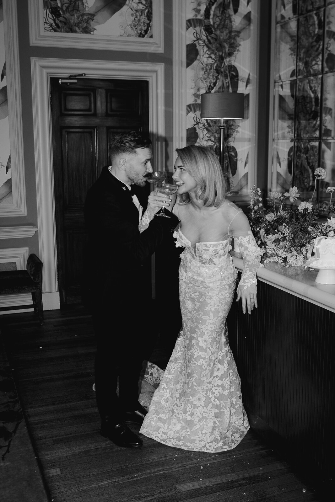 A wedding photographer captures the moment a bride and groom embrace during their first dance outside in the venue grounds.