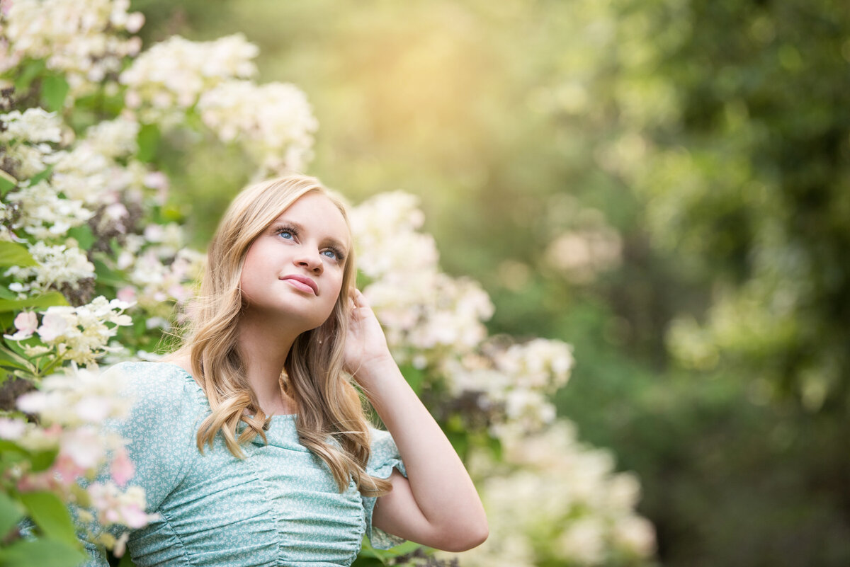 girl in blooming trees for senior photos