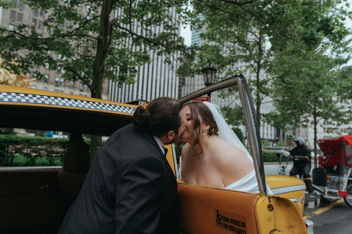 bride kiss outside of taxi after eloping shot by Elsie Goodman Photography | NYC Elopement Packages