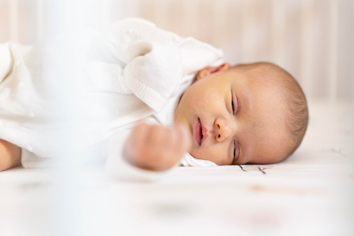 Baby laying on their side in crib during Atlanta newborn photography session