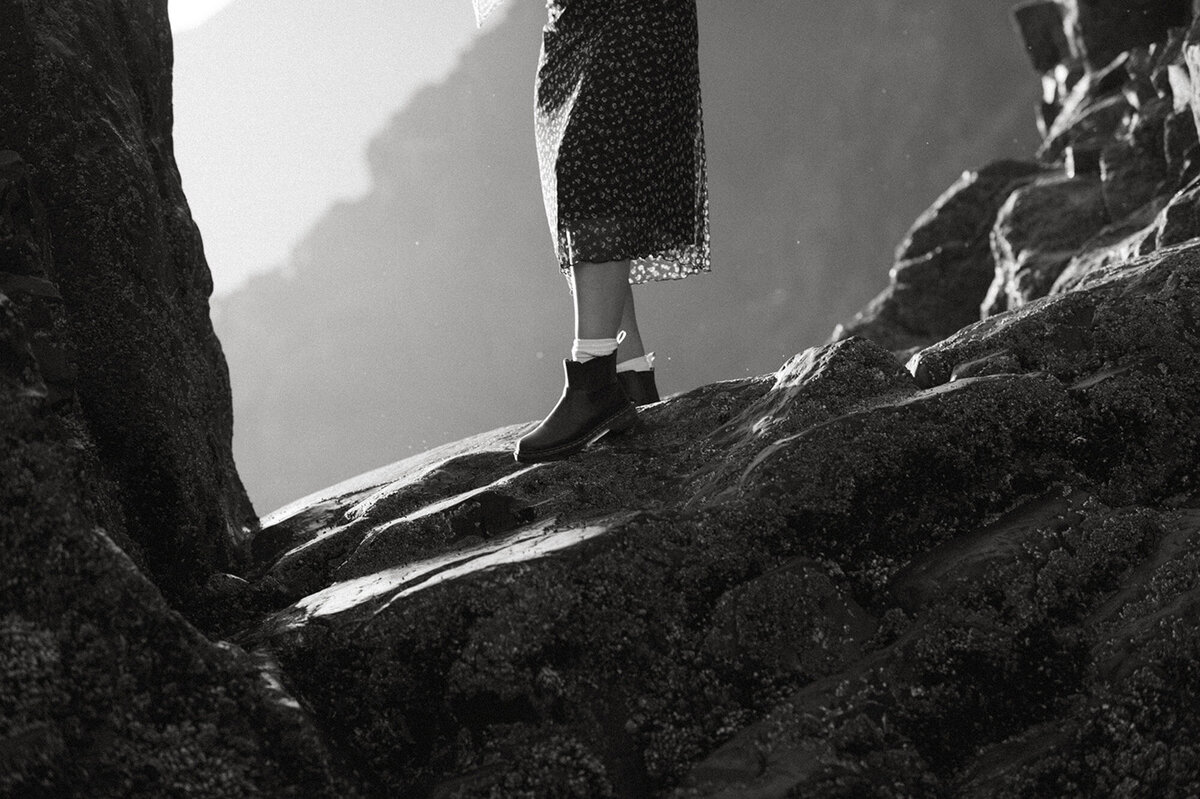 black and white portrait of girl walking on rocks