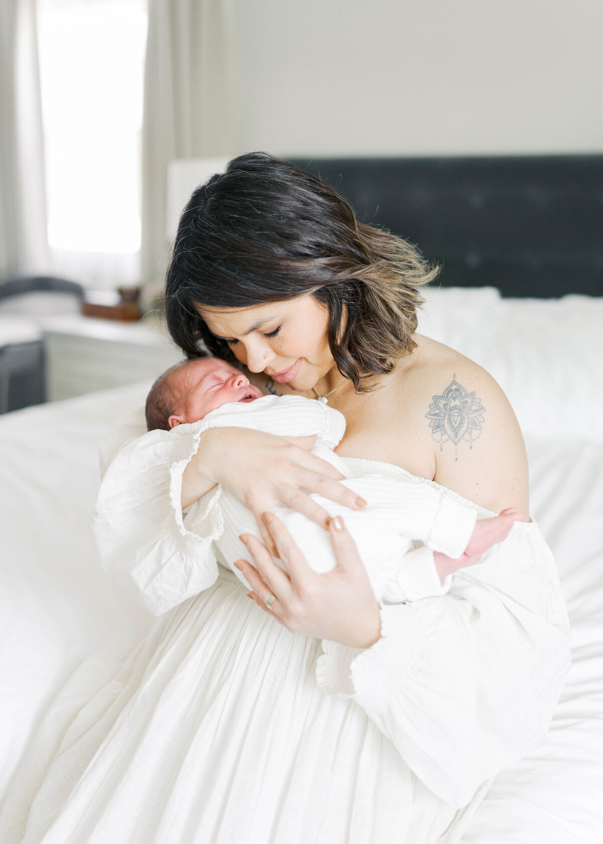 mother snuggling up to newborn baby in virginia beach newborn session