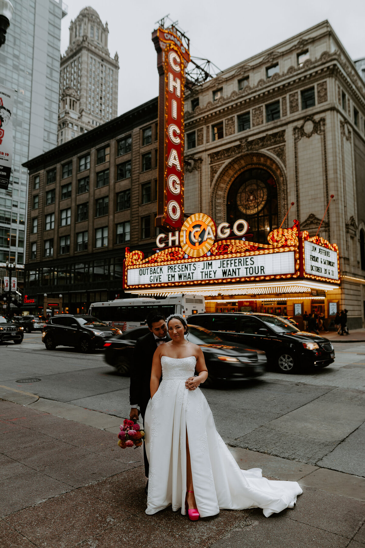 A Bride and Groom stand in front of the Chicago Theatre on their wedding day.