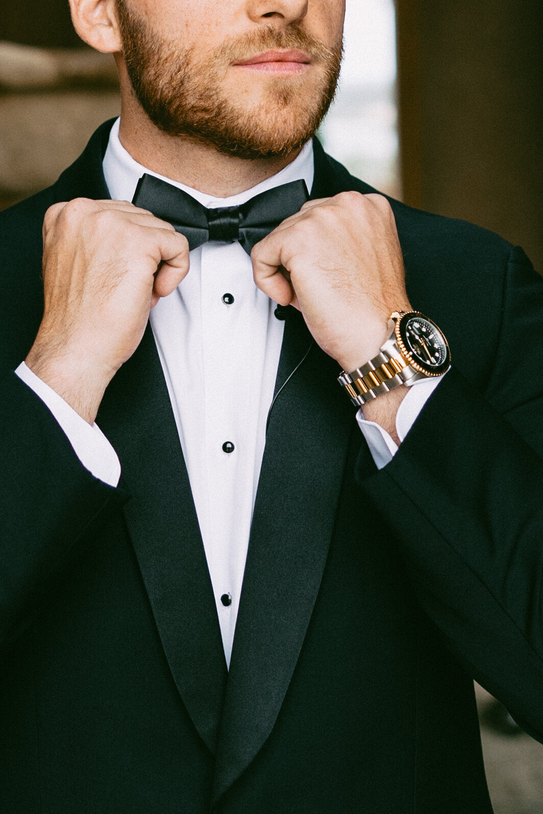 groom fixing tie at bella collina weddings & events​