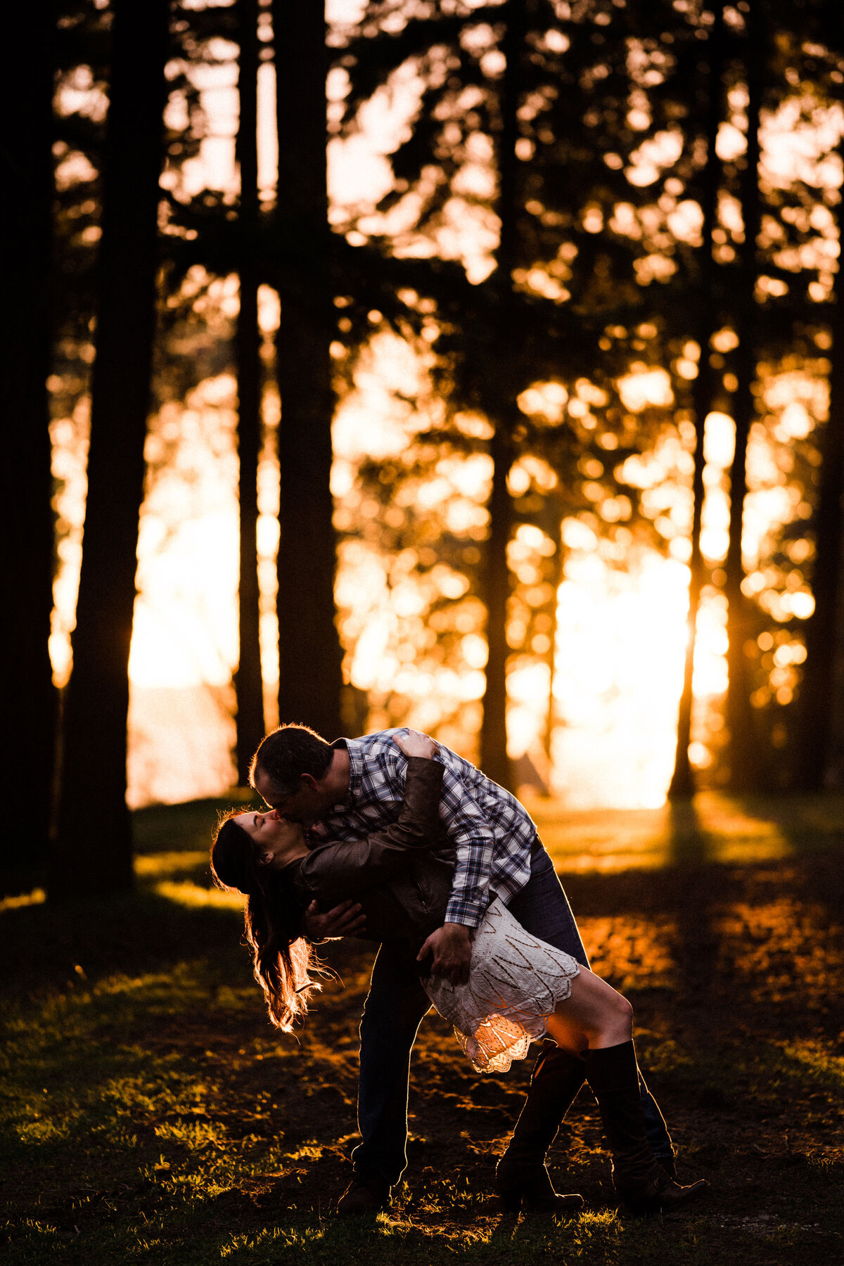 Couples kissing at Lincoln Park in West Seattle. Sunset, meadows, trees, beaches. It's one of the best spots for engagement photos in Seattle.